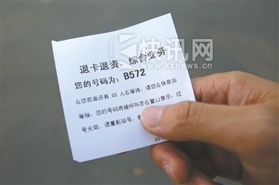 一名退卡者拿着的小条显示,在他前面还有65人在等候办理退卡业务。新京报记者 黄月 摄