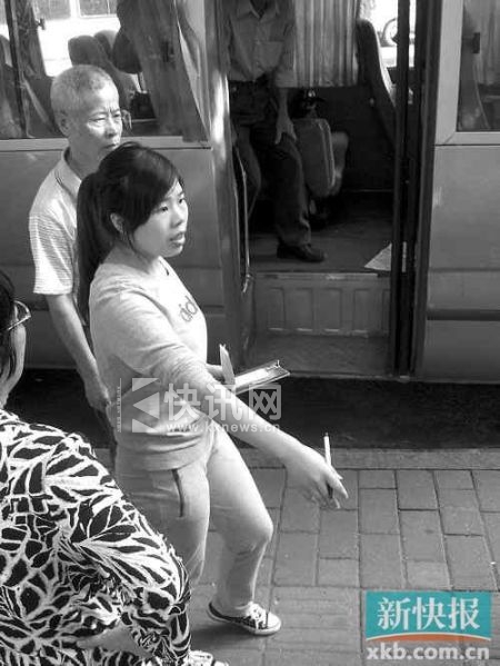 ■在购物点有一名女子在门口登记游客人数。