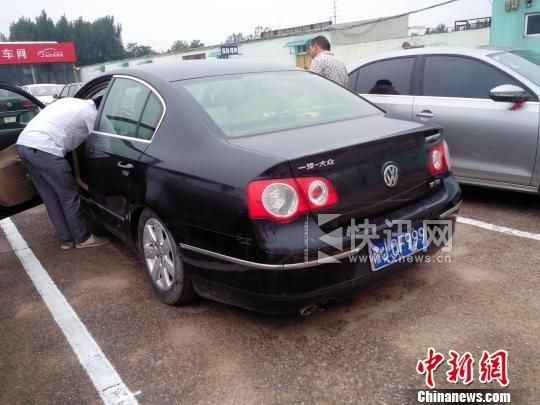 维修厂把拆下的机件全放在车后备箱,致车尾部严重下沉 董飞 摄