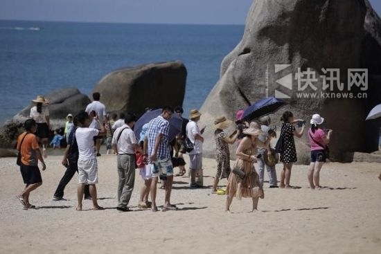 游客们在三亚“天涯海角”景点游览。澎湃新闻 黄俊如 图